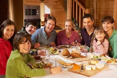 Two families eating at a cabin.