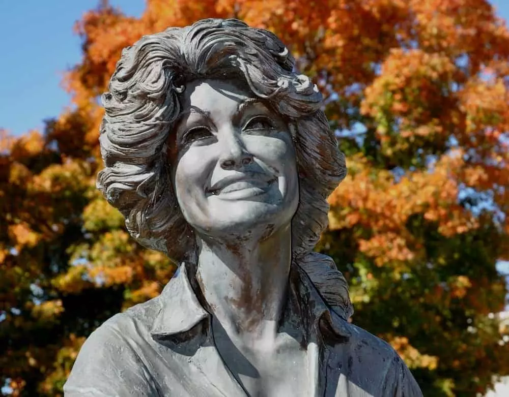 Dolly Parton statue with fall colors in background