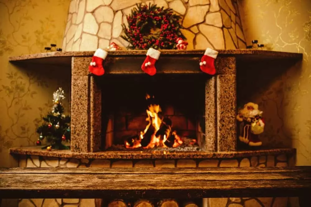 A fireplace in a cabin with Christmas decorations.