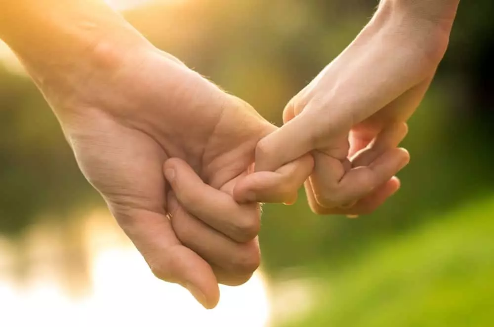 A couple holding little fingers.