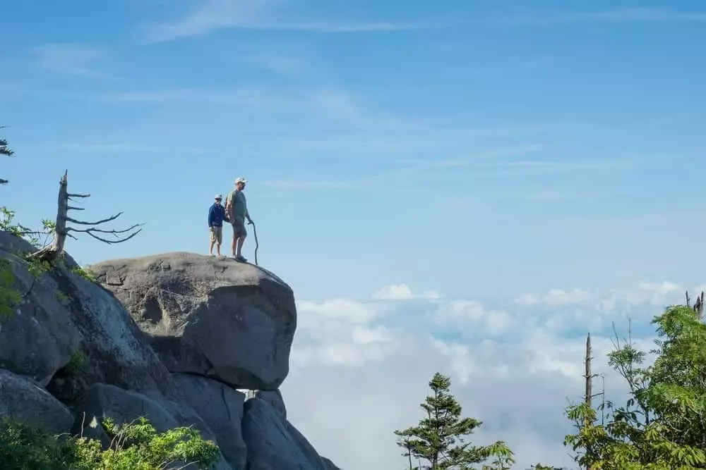 couple exploring Smoky Mountains admiring view from rock overlook