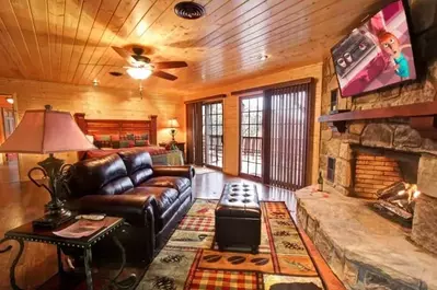 Bedroom with fireplace and living area at Gatlinburg rental cabin