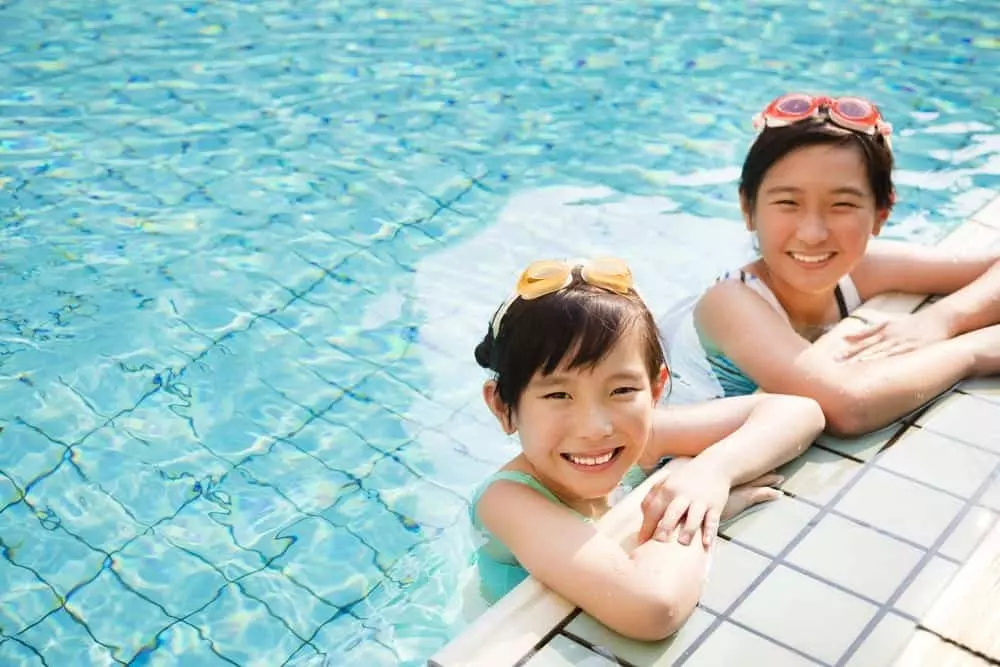Sisters swimming in a pool.