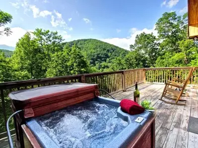 Hot tub and chairs on the deck of the Mountain Paradise cabin close to downtown Gatlinburg.