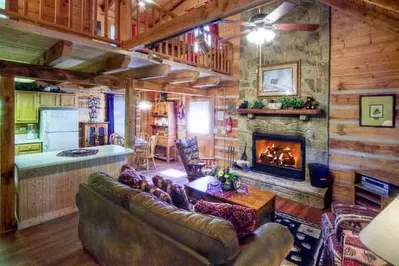 A charming living room with a stone fireplace in a Gatlinburg TN cabin rental.