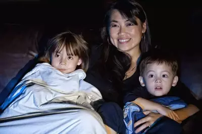 Mother and children watching a movie together.