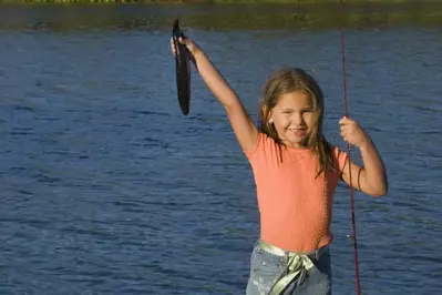 little girl holding fish she caught at Smoky Mountain fishing cabin