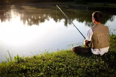 man fishing with pole and vast at Smoky Mountain fishing cabin